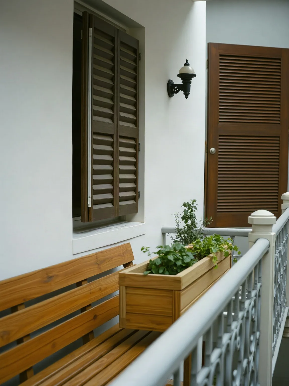 Panca e fioriera in legno su un balcone stretto con la ringhiera